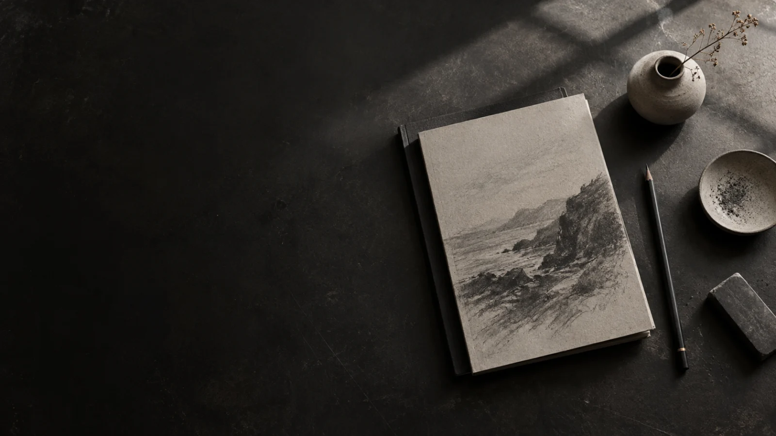 An editorial working surface with a sketchbook and pencil